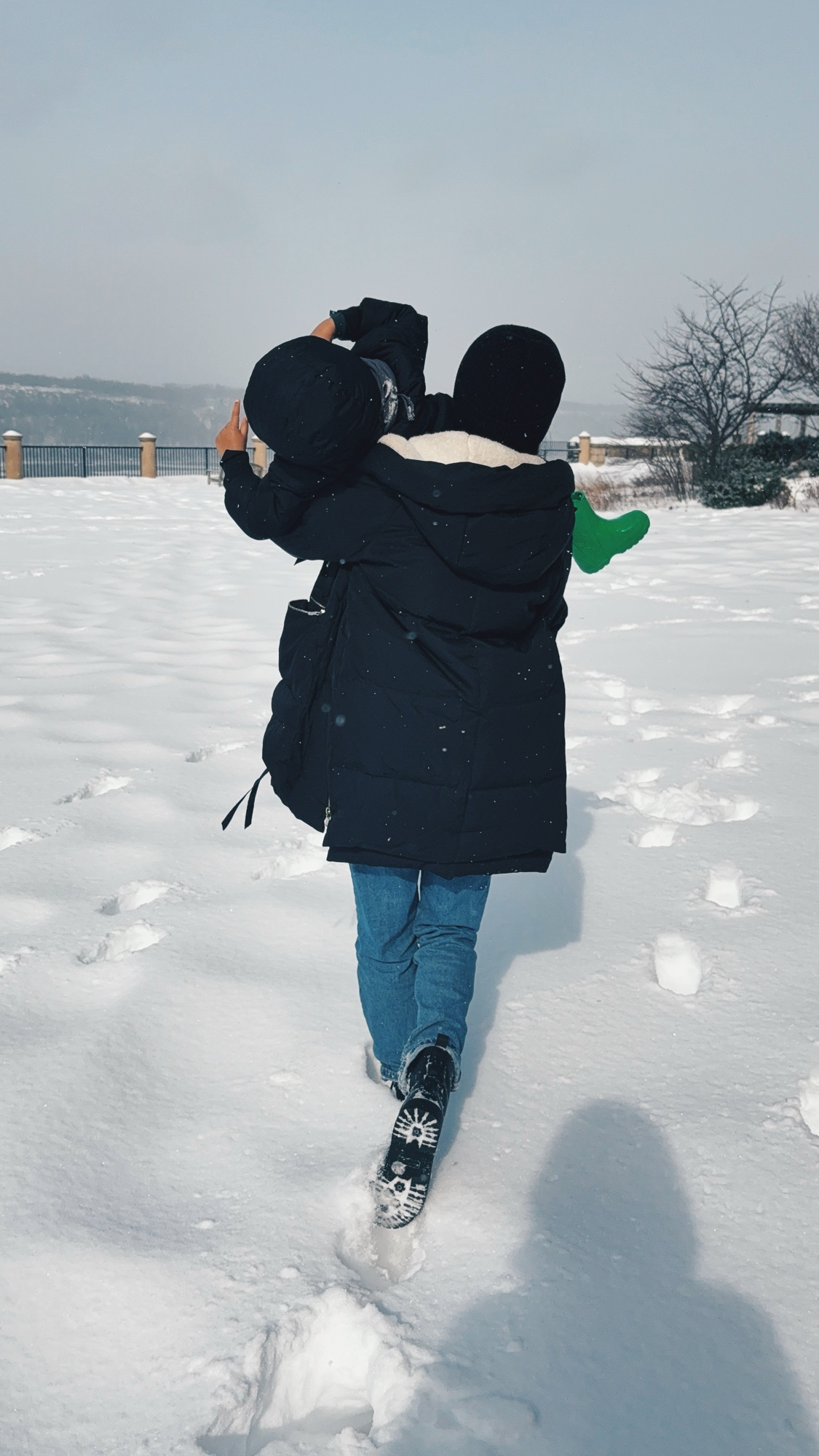 Essence and her son playing in the snow after the 2026 snowstorm, lots of flurries in the air and snow on the ground